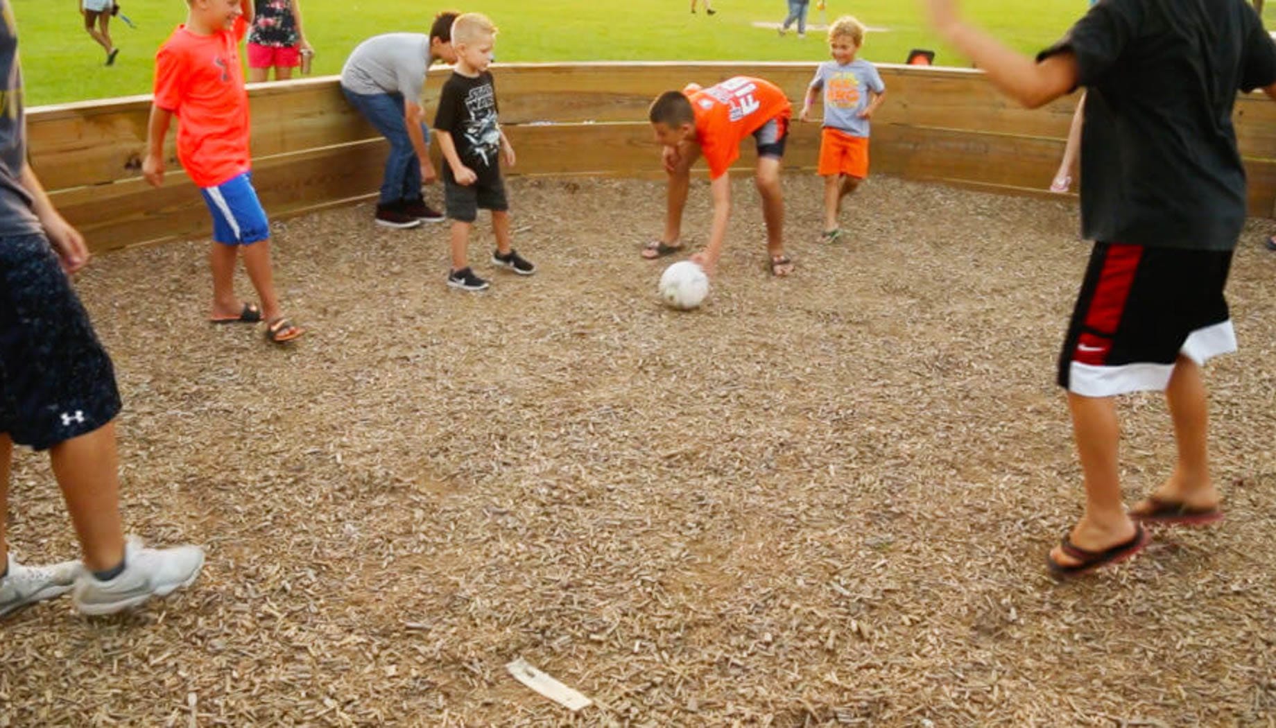 gaga Group of kids playing a game of Gaga Ball in a pit.