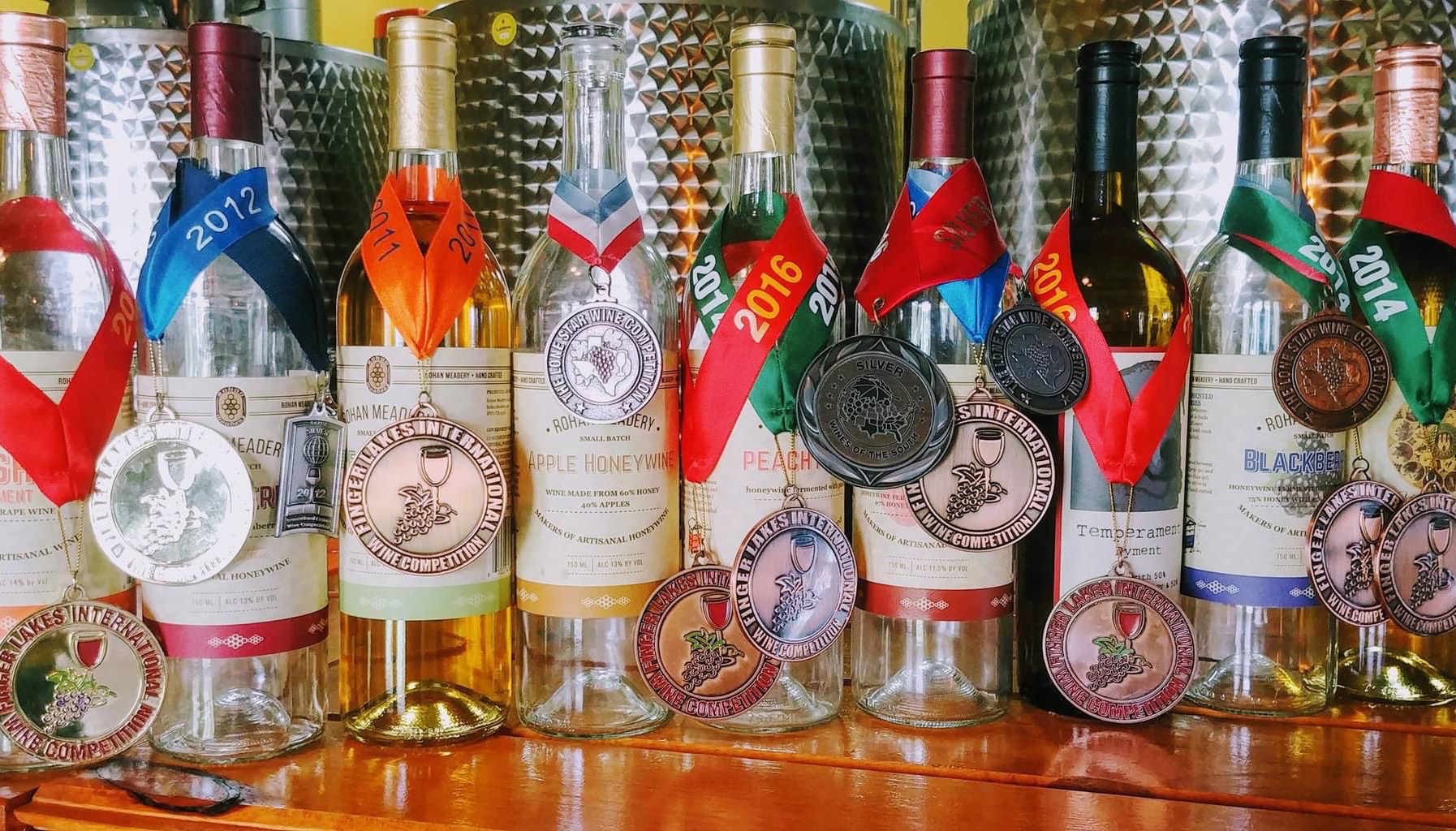 BLOG A row of wine bottles, each adorned with medals from various years, ranging from 2012 to 2016, and 2014.